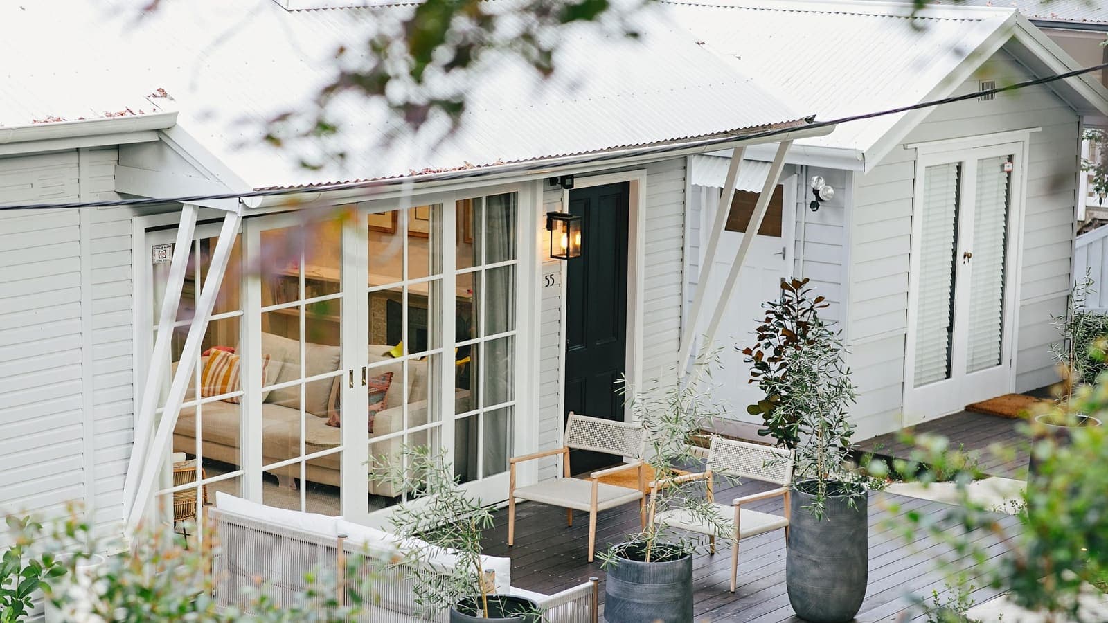 A weatherboard home in Auckland with a tidy front garden, photographed in spring sunshine