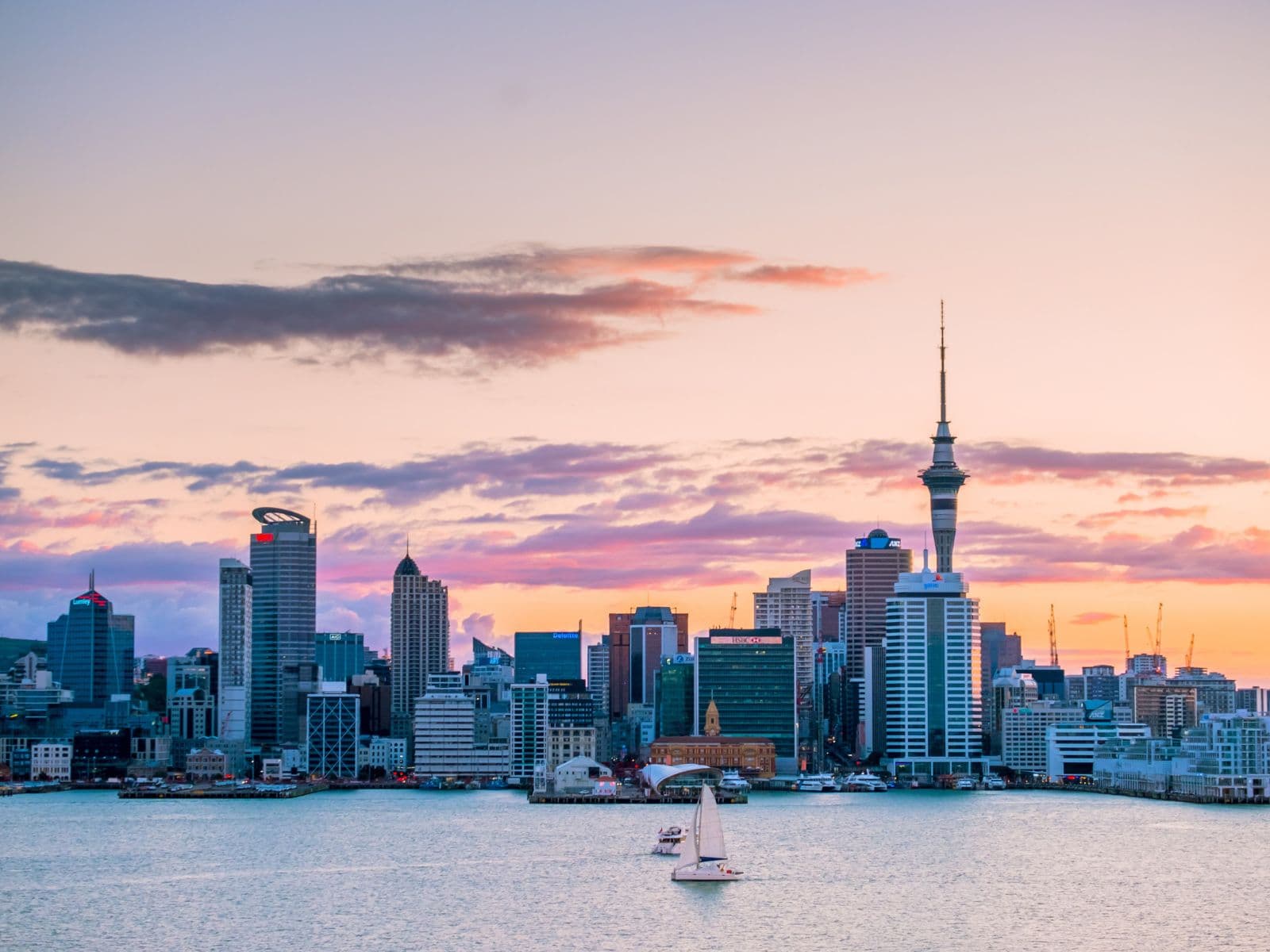 The Auckland city skyline and Sky Tower at sunset, seen across the harbour